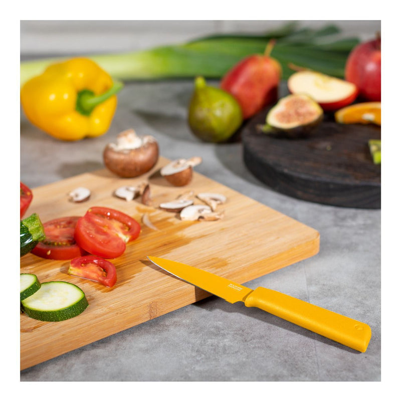 Kuhn Rikon | Colori+ Paring Knife - Yellow, featuring an ultra-sharp stainless steel blade, ideal for slicing and peeling on a cutting board.