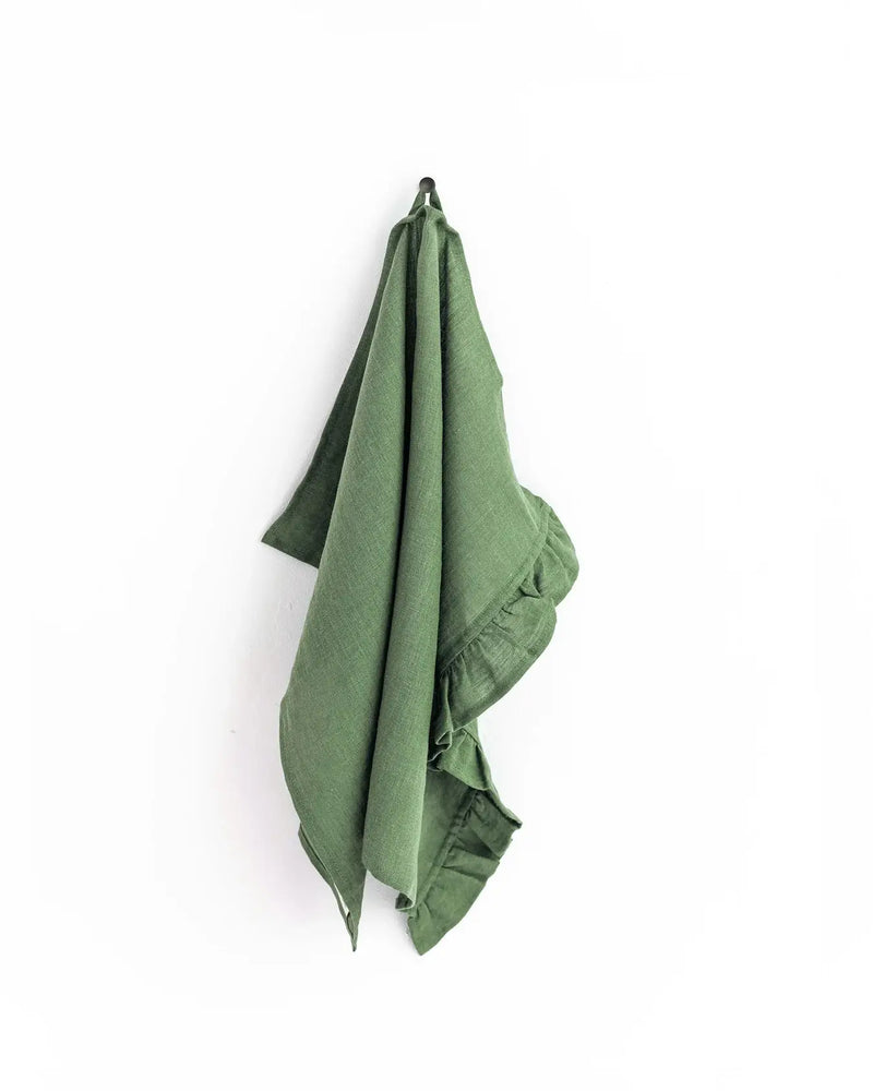 MagicLinen - Ruffle trim tea towel hanging on a hook, showcasing soft, absorbent linen with stylish ruffle detail, perfect for kitchen use.