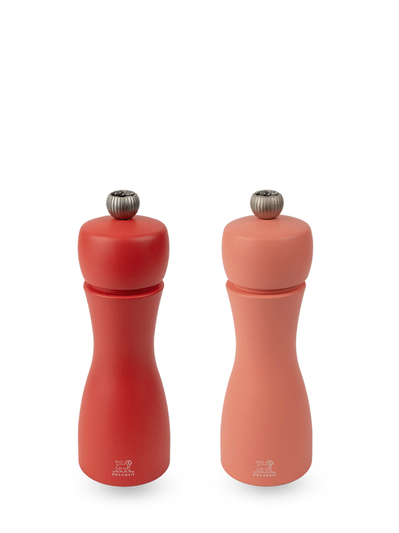 Peugeot | Tahiti Duo Salt + Pepper Mills, Fire: A matching set of red and coral-pink manual grinders, each with an adjustment knob and Peugeot lion logo.