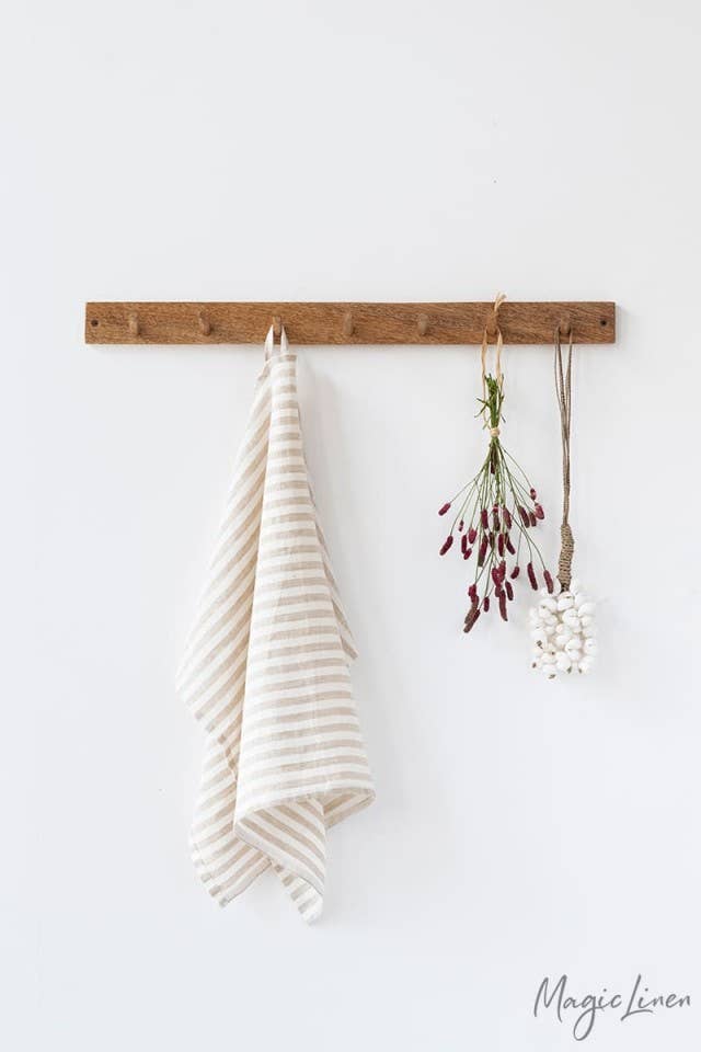 Linen tea towel on a hook, showcasing its absorbency and durability, perfect for any kitchen.