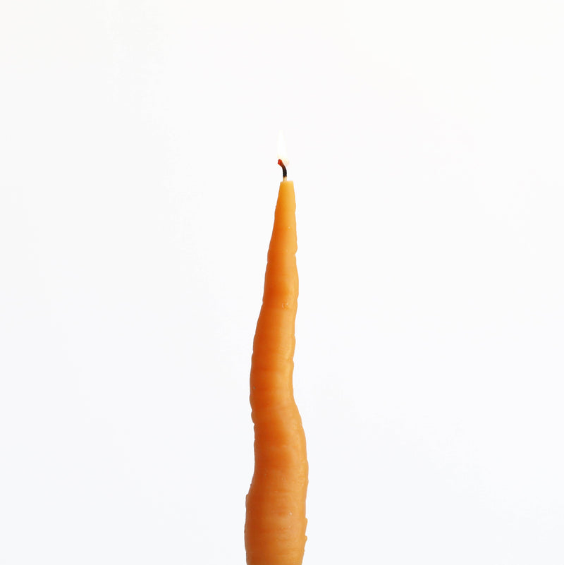 Artifaqt - Carrot Taper Beeswax Candle: Orange, shaped like a realistic carrot with a lit wick, showcasing its unique design and craftsmanship.