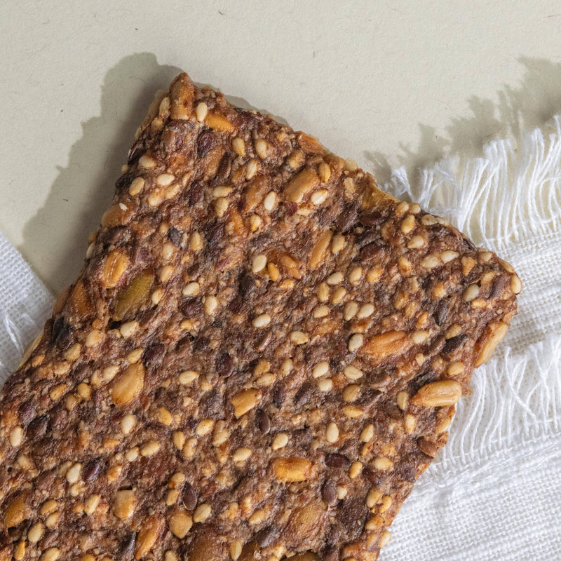 Potters Table - Gluten-Free Seeded Crisps: Close-up of a crunchy whole-grain cracker with embedded seeds, showcasing its texture and health-focused ingredients. Ideal for keto or vegan diets.