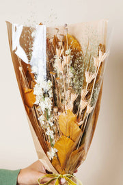 Idlewild Floral Co. - Golden Fall Market Bouquet: A rustic bouquet of dried beige blooms, poppy pods, grasses, and broad leaves, wrapped in kraft paper with green velvet ribbon.