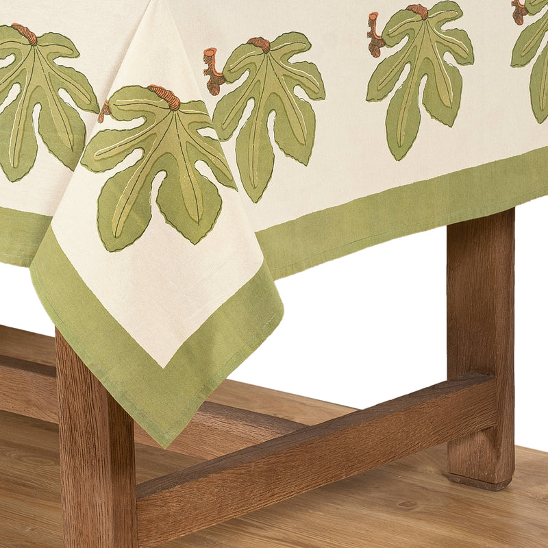Couleur Nature - Fig Red & Green French Tablecloth: 71 x 71, showcasing fig leaf pattern on cream linen, draped over oak furniture, designed by Bruno Lamy.