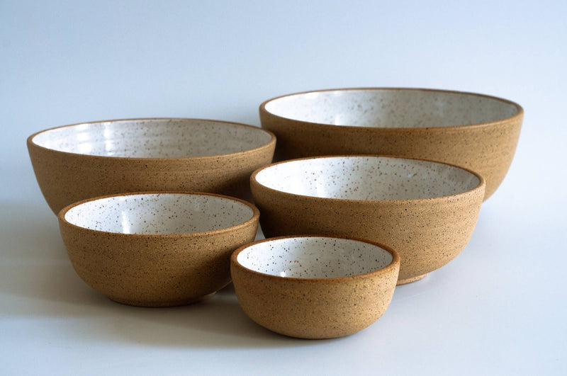 RachaelPots - Nesting Bowls Set Of Five: Nude/Light Blue, featuring a group of handcrafted ceramic bowls, ideal for versatile kitchen use, displayed on a white surface.