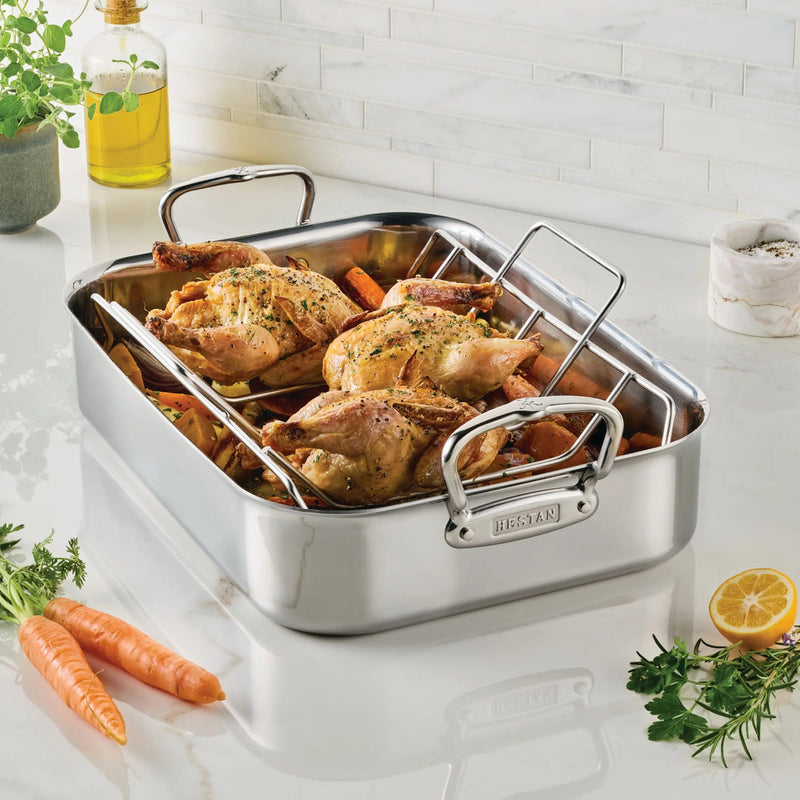 Hestan | Polished Clad Stainless Steel Roaster with Rack, Small, showcasing roasted birds and vegetables, ideal for enhancing your culinary creations with professional-grade performance.