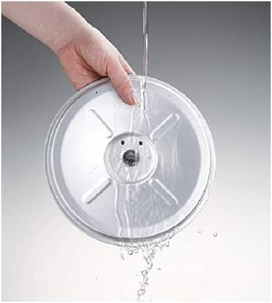 A hand rinses a round plastic disk, part of the Zojirushi Micom Rice Cooker Warmer - Stainless Brown, under running water, emphasizing its easy cleaning feature.