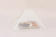 NEEPA HUT | Collapsible Woven Food Tent - Rose Pink, elegantly covering fruit on a cutting board, showcasing its unique handmade design for stylish outdoor dining.