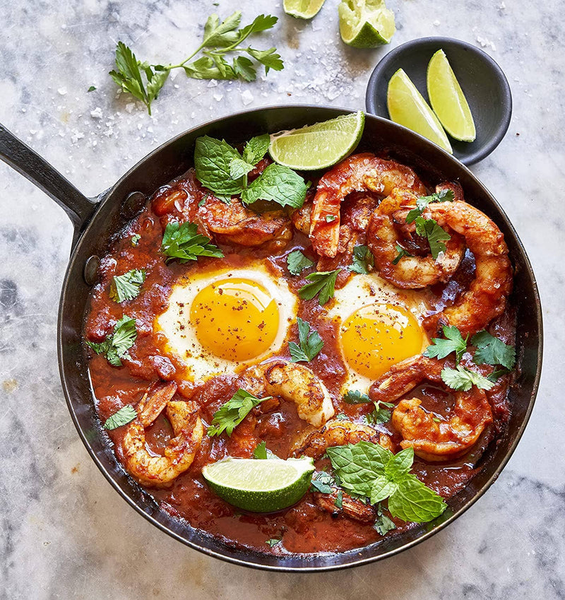 Villa Jerada - Kefta Rub - 50g enhances shakshuka with sautéed shrimp, fresh herbs, and lime wedges, reflecting Moroccan culinary influences.