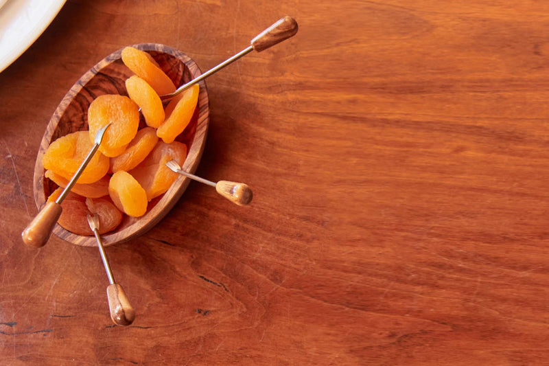 Italian Olivewood Aperitivo Bowl filled with dried apricots and small metal picks, showcasing artisanal craftsmanship from Umbria, Italy. Perfect for serving appetizers.