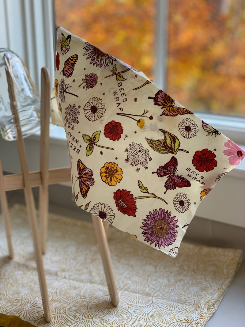 Bee's Wrap - Assorted 3 Pack - Meadow Magic, Plant-Based Wax draped over light-wood drying rack, featuring floral and butterfly prints.
