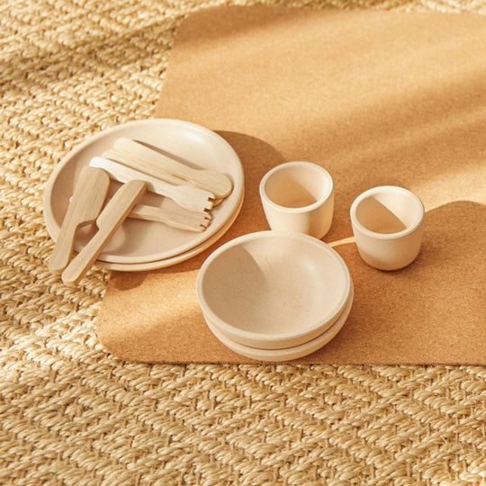 PlanToys | Kids Pretend Playtime Tableware Toy Set featuring wooden utensils, ceramic plates, bowls, and cups on a mat, perfect for children's imaginative play.