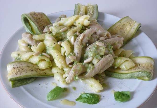 Zia Pia - Fidanzati Capresi pasta dish with zucchini pesto, pine nuts, and basil garnished on a white plate, highlighting La Fabbrica della Pasta's artisanal craftsmanship.