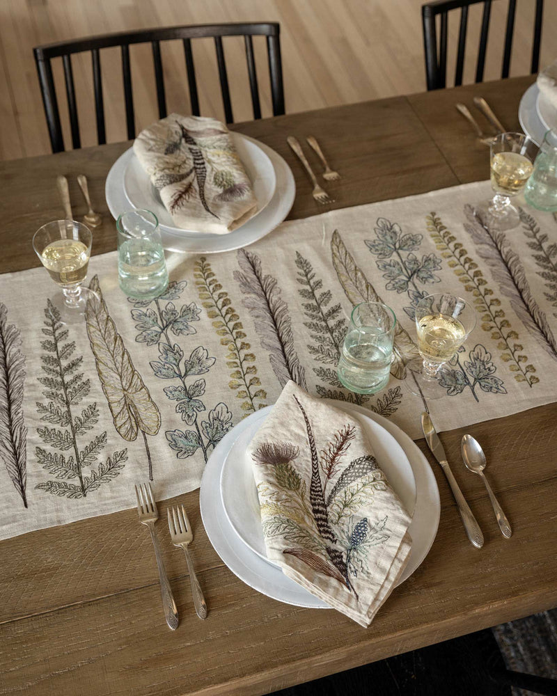 Coral & Tusk - Thistle Dinner Napkin features embroidered foliage, elegantly displayed on a set table with a nature-inspired theme, enhancing a cozy, rustic dining experience.