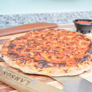 Lamson | 12 Pizza Rocker with Walnut Handles on a cutting board, showcasing its precision slicing tool for clean pizza cuts, ideal for Athens Cooks' curated kitchen collection.