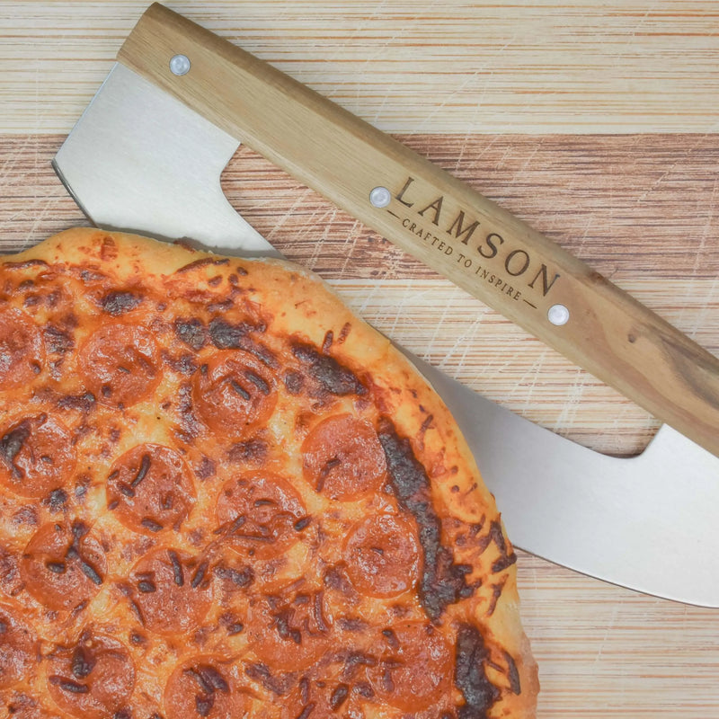 Lamson | 12 Pizza Rocker with Walnut Handles on a wooden surface, designed for precise pizza cutting without displacing toppings.