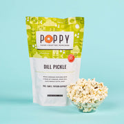 Poppy Hand-Crafted Popcorn - Dill Pickle Popcorn, featuring a market bag and bowl filled with popcorn, highlighting its white cheddar, vinegar, and dill flavor.
