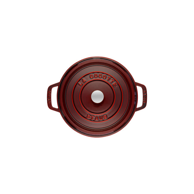 Top-down view of Staub | Round Cocottes - 5.5 qt Grenadine, featuring a cherry-red, enameled cast-iron design with side handles and a metal-knobbed lid.