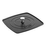 Staub Cast Iron Square Grill Press in black, featuring a heavy, enameled finish with concentric rings and a central stainless-steel knob for even browning and moisture retention.