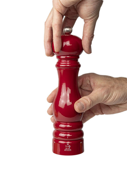 Peugeot | Paris Chef u'Select Passion Red Pepper Mill, 9 inches, being gripped and ready to grind peppercorns with its adjustable grind setting.