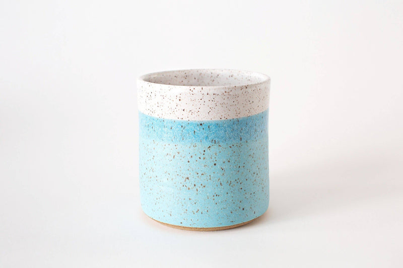 RachaelPots - Kitchen Utensil Holder: Sage. A small, cylindrical, hand-thrown ceramic vessel with speckled blue and white glaze, perfect for organizing kitchen utensils.