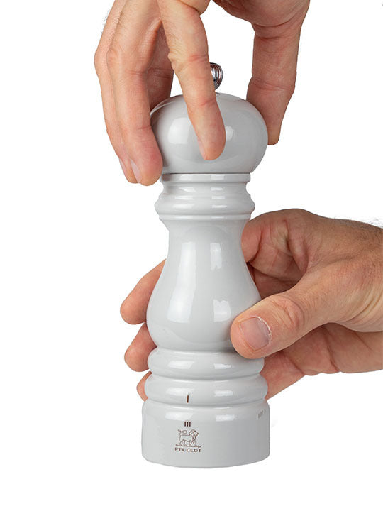 Peugeot | Paris U'Select Salt Mill, Pearl Grey, shown in use, demonstrating its ergonomic design and adjustable grinding settings for precise salt texture control.