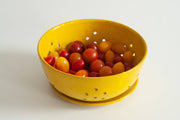 RachaelPots - Large Berry Bowl With Dish: Black, showcasing a yellow perforated design filled with colorful cherry tomatoes, ideal for draining and displaying, hand-thrown ceramic from Brooklyn.