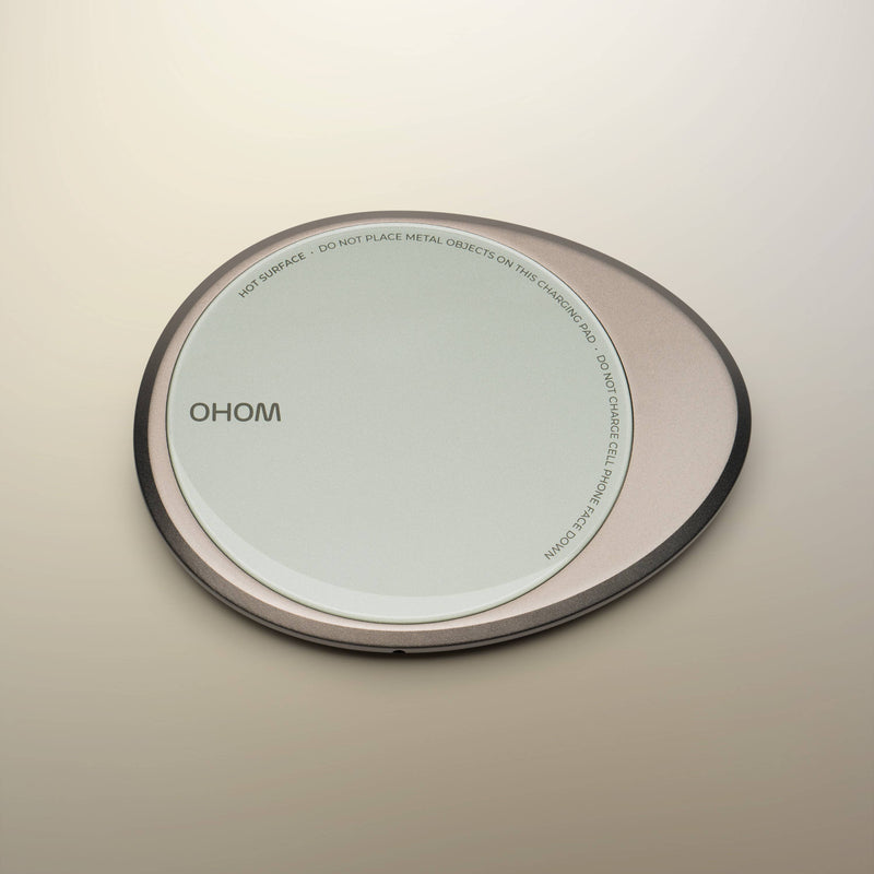 OHOM - Ui 3 Self-heating Mug Set: Jasmine White with a Qi-style wireless charging pad, featuring safety warnings on its rim.