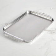 Hestan | OvenBond Tri-Ply Bakeware, Single Half Sheet Pan with rolled edges and built-in handles, showcased on a marble-style countertop, ideal for even heat distribution and durability.