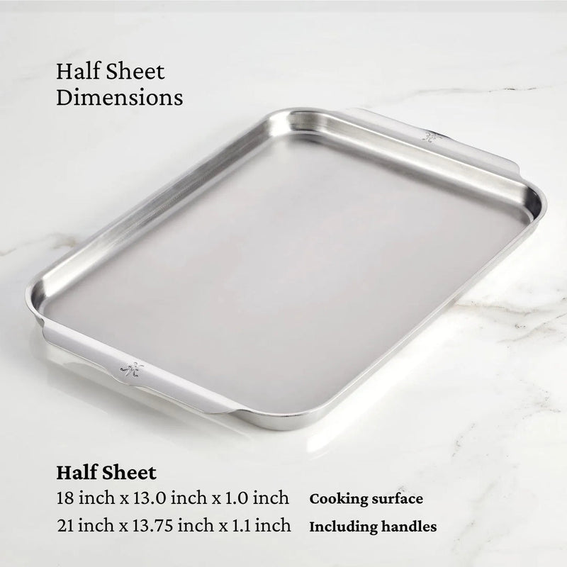 Hestan | OvenBond Tri-Ply Bakeware, Single Half Sheet Pan on marble countertop, showcasing its durable stainless steel build with wide handles for easy oven removal.
