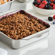 Hestan Provisions | Oven Bond Tri-Ply Bakeware, Square Baker filled with berry crisp, showcasing even baking, with a bowl of fresh berries beside it.