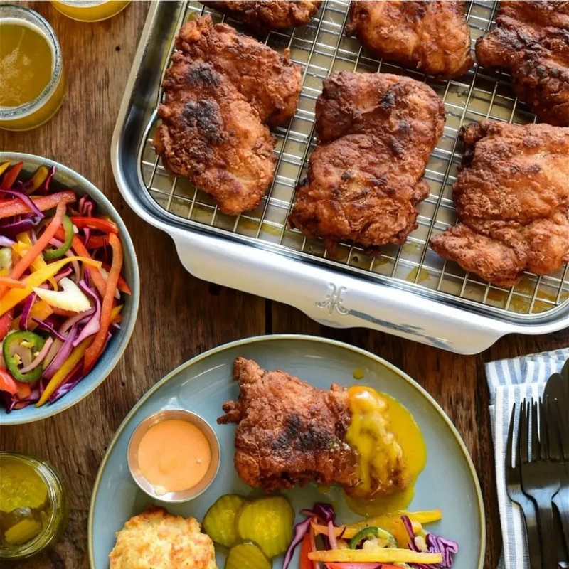 Hestan Provisions OvenBond Medium Sheet Pan showcasing crispy fried chicken, slaw, and pickles, highlighting even heat distribution and durability on a rustic kitchen table.