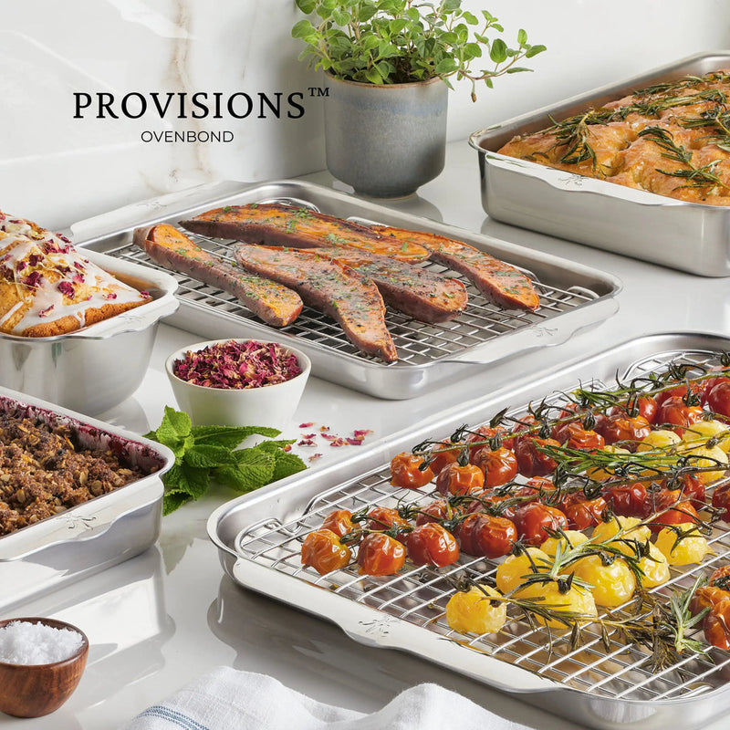 Hestan | OvenBond Tri-Ply Bakeware, Half Sheet with a single rack, showcasing roasting tomatoes, sweet potatoes, and a loaf cake, with bowls of salt and herbs.