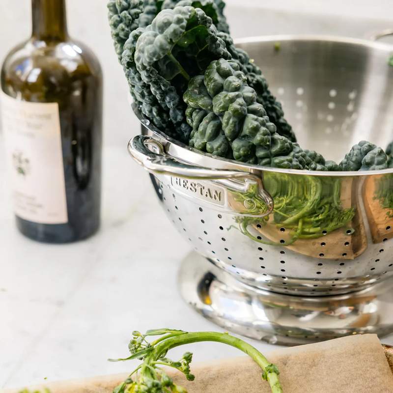 Hestan Provisions Stainless Steel Colander, 5 Quart, filled with lacinato kale, offers excellent drainage, ideal for rinsing fresh produce in your kitchen.