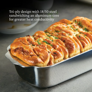 Hestan Provisions | OvenBond Tri-Ply Bakeware, 1-Pound Loaf Pan with cheese-and-herb bread, showcasing wide handles and tri-ply construction for even heat distribution.