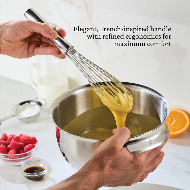 Hestan Provisions | Stainless Steel French Whisk, 9 held above a bowl of batter, highlighting its elegant handle and fine craftsmanship.