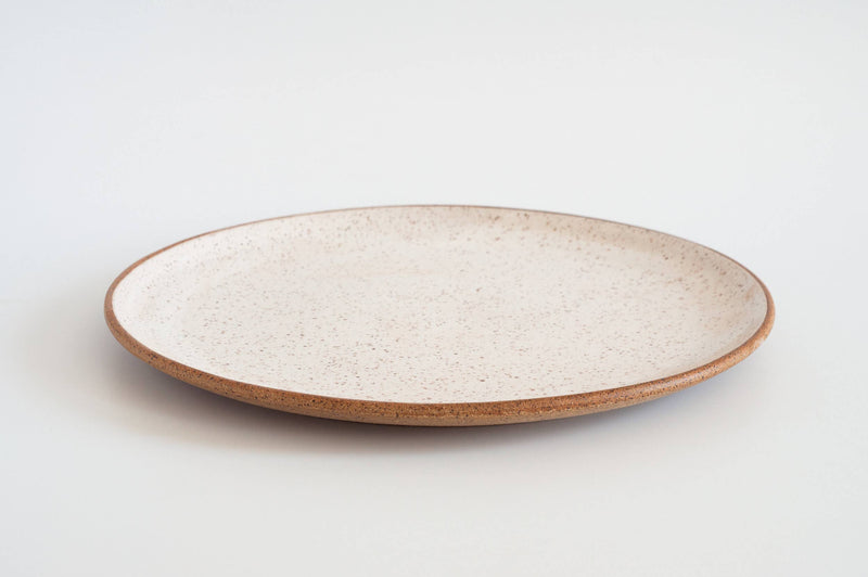 RachaelPots - Serving Platter: Sage, a handmade, off-white ceramic plate with an earthy brown rim, perfect for showcasing dishes, crafted from speckled stoneware.
