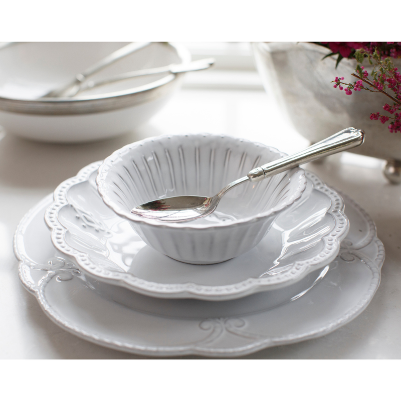 Arte Italica & Crown Linen Designs - Bella Bianca Beaded Cereal Bowl with spoon, stacked on plates, showcasing elegant Italian stoneware craftsmanship, available at Athens Cooks.