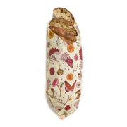 Bee's Wrap - Bread Wrap - Meadow Magic, Plant Based Wax, wrapping crusty bread slices with decorative floral and butterfly print, ideal for keeping bread fresh.