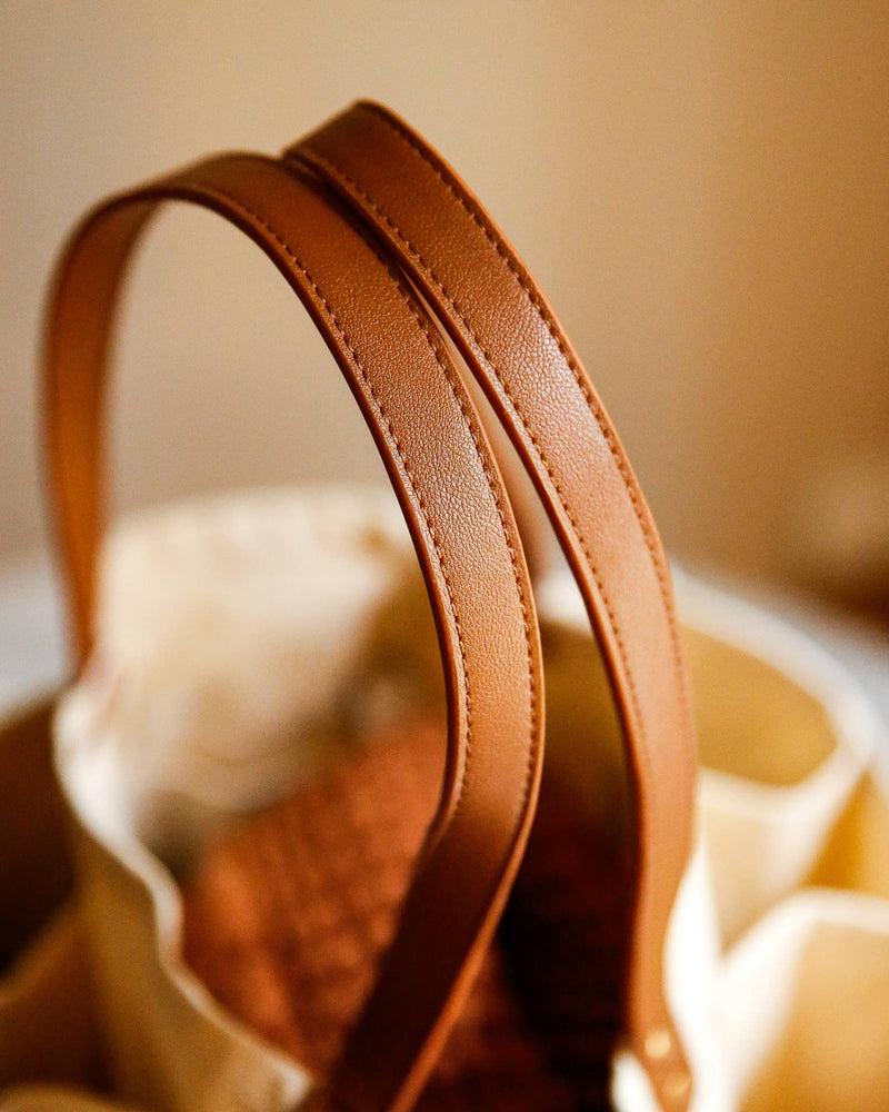 Close-up of tan-brown leather straps on the CapaBunga® Deluxe Canvas Market Tote, highlighting premium materials and craftsmanship for stylish, eco-friendly carrying solutions.