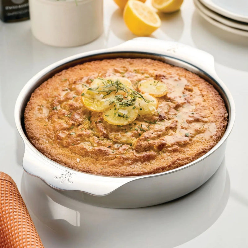 Hestan | OvenBond Round Baker 9 NEW showcased with a close-up of food, highlighting its use in baking within the Athens Cooks kitchenware collection.