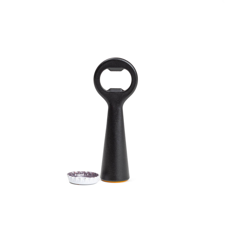 L'Atelier du Vin - USA - Bottle Opener - LE BRASSEUR – BLACK, stainless steel with a black handle, stands upright by a removed bottle cap, showcasing its sleek, functional design.