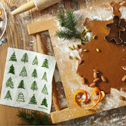 Three Bluebirds Swedish Dishcloths, featuring a whimsical holiday design, are shown with a wooden rolling pin and dough on a cutting board.