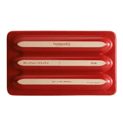 Emile Henry | Baguette Baker, Burgundy: A ceramic baker with three molds for baguettes. Features ribs for non-stick baking and a lid for ideal humidity. Made in France.