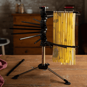 Marcato Tacapasta Pasta Drying Rack, Red, displaying freshly cut pasta sheets drying evenly on a compact tabletop stand, ideal for small kitchen spaces.