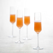Zwiesel Fortessa | Pure Champagne Flute, Single: Four elegant crystal glasses filled with orange cocktail, highlighting modern design and sophistication, perfect for enhancing dining experiences.