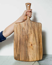 Petermans Boards and Bowls Inc. 27 ambrosia maple serving board with handle, handcrafted and sustainably sourced in New England, ideal for versatile kitchen use.