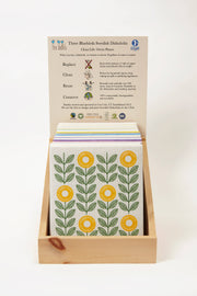 Three Bluebirds Swedish Dishcloths - Cornflowers Swedish Dishcloth in a display box, featuring floral designs, ideal for reducing waste and cleaning efficiently.