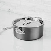 Hestan NanoBond 1.5qt Saucepan with Lid on white countertop, featuring ergonomic handles and durable titanium stainless steel construction for efficient heating and precision pouring.