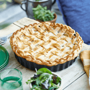 Emile Henry Deep Flan & Tart Dish, 2.1QT, showcased with a freshly baked lattice-top pie, highlighting its rustic charm on a weathered wooden tabletop.